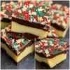Delicious layered Christmas fudge bars decorated with festive red, green, and star-shaped sprinkles, showcasing a wonderful Christmas fudge recipe.