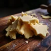 Close-up of star-shaped raw dough pieces on a rustic wooden board, perfect for a festive christmas cookie dough recipe.