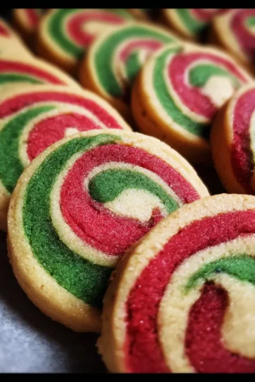 Delicious homemade Christmas pinwheel cookies recipe, beautifully arranged with vibrant red and green swirls.