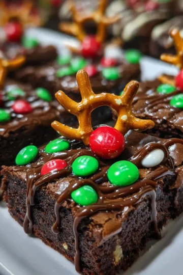 Festive chocolate brownies adorned as reindeer with pretzel antlers and red candy noses, showcasing a delightful Christmas reindeer brownie recipe.