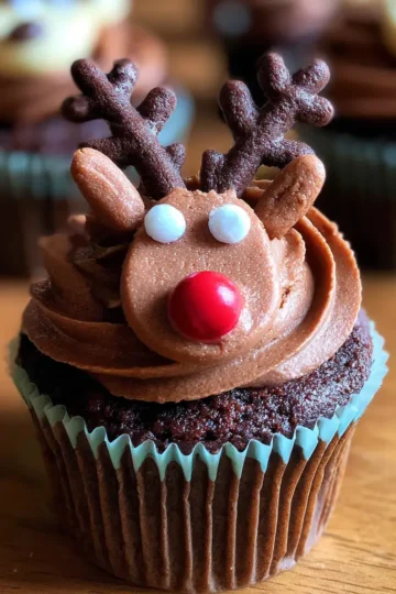 Delicious chocolate Christmas reindeer cupcake recipe with festive red nose and antler decorations.