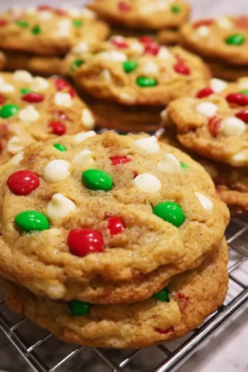 Freshly baked Christmas Santa cookie recipe cooling, studded with festive red and green candies and white chocolate.