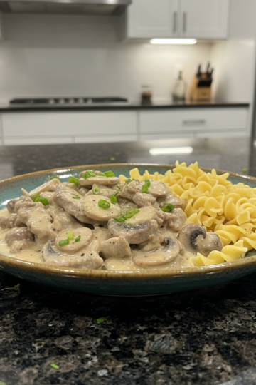 A creamy bowl of homemade Beef Stroganoff with tender beef, mushrooms, and noodles, garnished with fresh parsley.