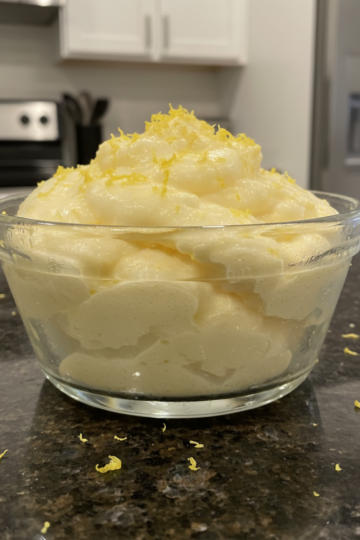 A vibrant, creamy lemon dessert garnished with fresh mint and a lemon slice, perfectly chilled and ready to serve.