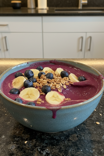 A vibrant, thick smoothie bowl recipe topped with fresh berries, banana slices, and granola, ready to eat.