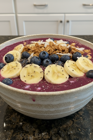 A vibrant berry smoothie bowl recipe topped with fresh fruit, granola, and coconut flakes, ready to enjoy.