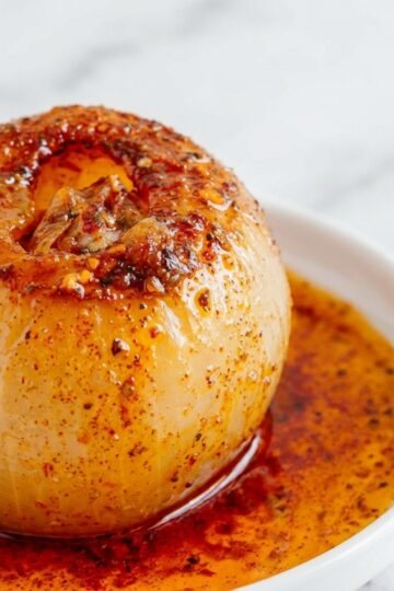 Tender Vidalia onions in a minimalist ceramic bowl glazed with umami miso-maple on a white marble surface.